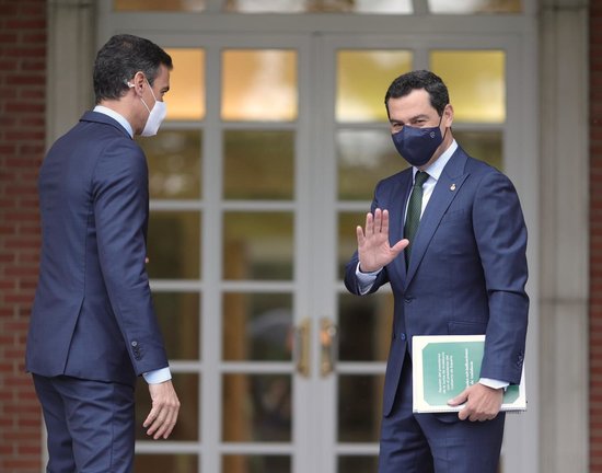 El presidente de la Junta de Andalucía, Juan Manuel Moreno Bonilla (d) saluda a su llegada al Palacio de Moncloa antes de su reunión con el presidente del Gobierno, Pedro Sánchez (i), a 17 de junio de 2021. Se trata de la primera reunión oficial de ambos 