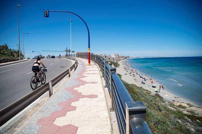 Archivo - Una ciclista circula cerca de la Playa Galúa, en la Manga del Mar Menor, en Cartagena, Región de Murcia (España). 