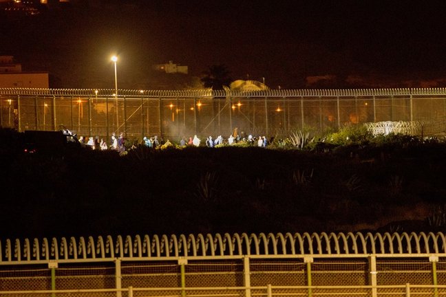 Archivo - Varios marroquíes intentan llegar a suelo español desde la frontera que separa Melilla y Marruecos, a 21 de mayo de 2021, en Marruecos. La noche de este viernes medio centenar de personas ha intentado llegar a suelo español pero las fuerzas y cu