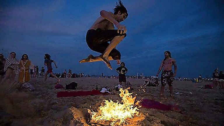Una persona salta una hoguera en una playa en la última celebración de esta festividad. / alerta