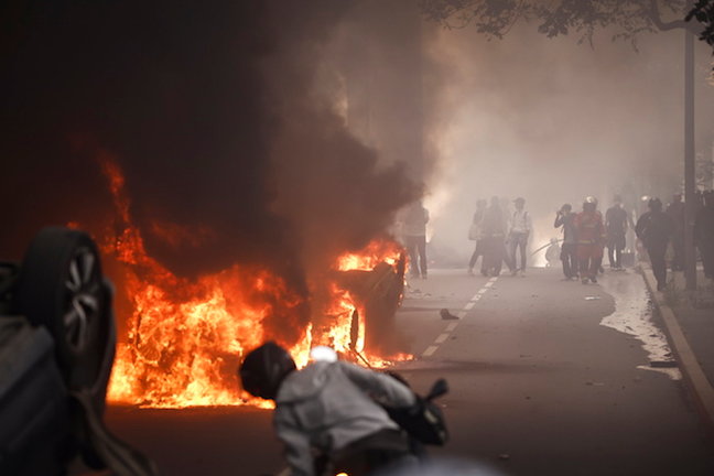 Un incendio arde en plena calle durante los enfrentamientos entre manifestantes y la policía antidisturbios francesa. / YOAN VALAT