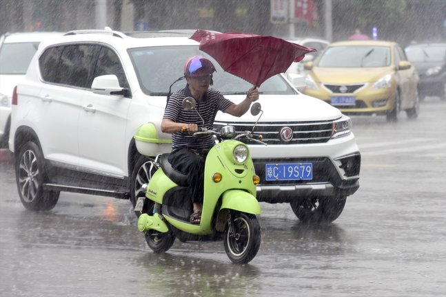 Un hombre cicula en su motocicleta bajo unas fuertes lluvias. - Europa Press/Contacto/Meng Zhongde - Archivo