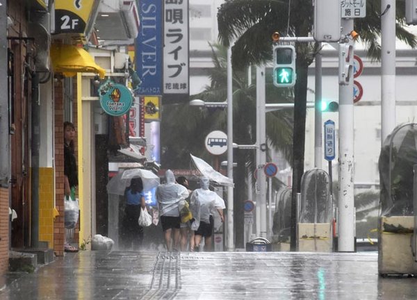 La gente camina a lo largo de Kokusai-dori bajo el fuerte viento y la lluvia del tifón Khanun en Naha, Prefectura de Okinawa, Japón,este 2 de agosto de 2023. EFE/EPA/Jiji Press Japan
