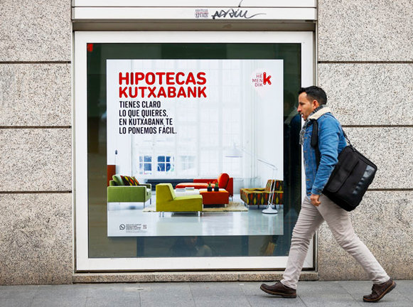 Un hombre pasa delante de un cartel que ofrece hipoteca. EFE/Luis Tejido