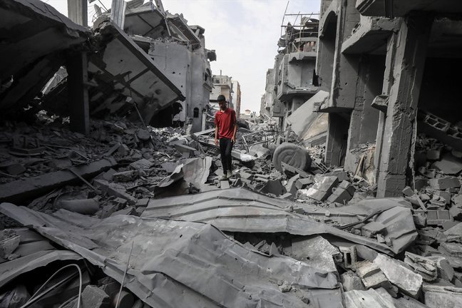 Un hombre caminando entre los escombros de unos edificios en Gaza.  Omar Naaman