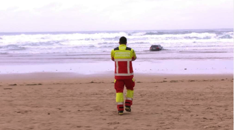 Un técnico del 112 Cantabria y el vehículo en la orilla de la playa de Oyambre. / 112