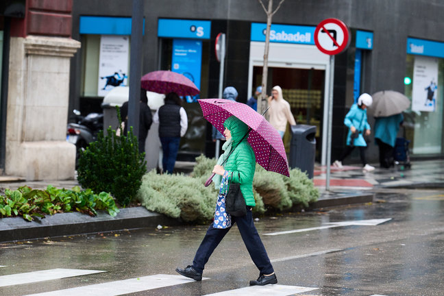 Una persona se cubre de la lluvia y el viento con paraguas en Santander. / Juanma Serrano