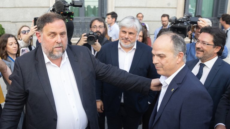 El presidente de ERC, Oriol Junqueras (i) y el secretario general de Junts, Jordi Turull (d), se saludan tras quedar aprobada la Ley de Amnistía. Eduardo Parra