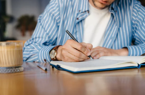 Una persona escribiendo en un cuaderno. / A.S.