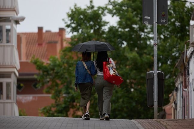 Dos mujeres se protegen de la lluvia con un paraguas. Jesús Hellín / Archivo