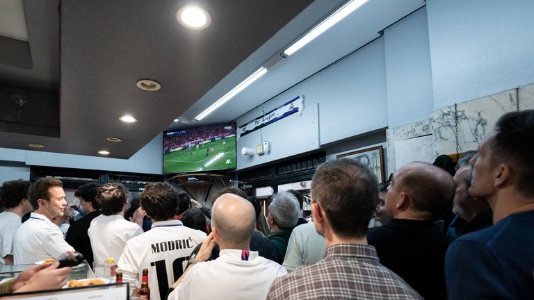 Varias personas disfrutan de la emisión del partido de ida de semifinales de la Champions en Múnich. / Diego Radamés