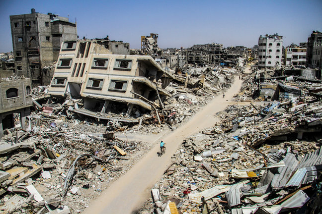 Palestinos entre edificios destruidos por los ataques. / eP