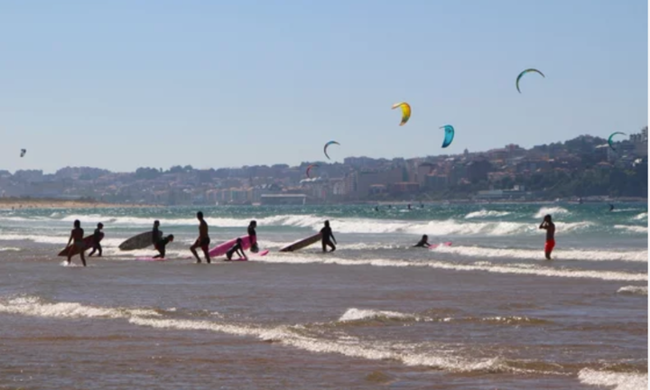 Varias personas disfrutan de la playa de Cantabria.