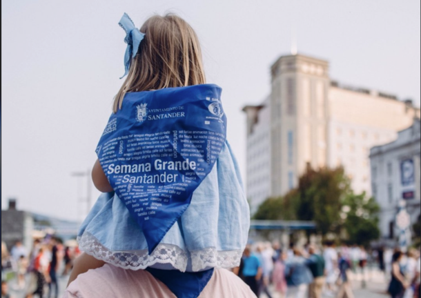 Una niña a hombros por la zona donde están situadas las casetas de la Feria de Dia de la Semana Grande de Santander.