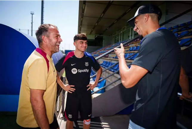 El entrenador del FC Barcelona, Hansi Flick, charla con sus jugadores Pedri y Ronald Araujo en la Ciutat Esportiva Joan Gamper. /Germán Parga