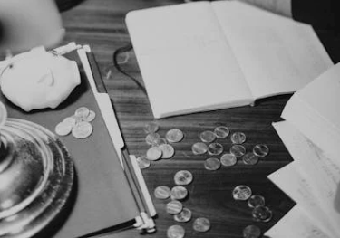 Una persona con varias monedas encima de una mesa. / A.E