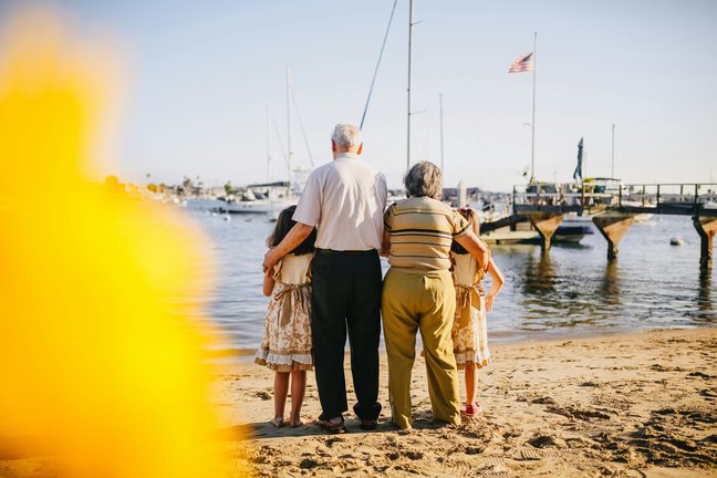 Dos niñas frente al mar con sus abuelos. / A.E
