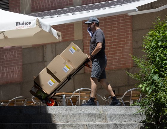 Un hombre sujeta varias cajas mientras las traslada. EP