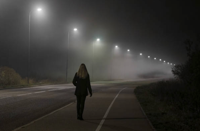 Una mujer caminando por la carretera.