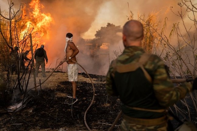 Voluntarios extinguen un incendio forestal en Ano Patima, cerca de Penteli, en la región septentrional de Atenas. Los Estados miembros de la UE están enviando ayuda a Grecia para ayudar a los servicios de emergencia en la lucha contra el mayor incendio forestal del año en el país el lunes, con múltiples focos ardiendo en unos 200 kilómetros cuadrados de bosques al noreste de la capital Atenas. Foto: Socrates Baltagiannis/dpa