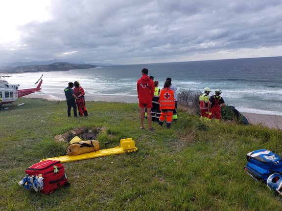 Personal de Cruz Roja Cantabria y una ambulancia atienden a una persona accidentada en parapente en la zona de Gerra, San Vicente de la Barquera, a la espera de la llegada del helicóptero y bomberos. / X