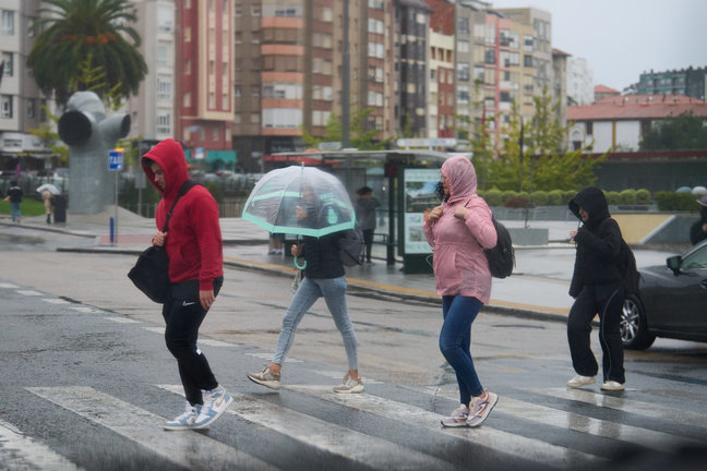 Varias personas se cubren de la lluvia y el viento con paraguas en Santander. / J.S.