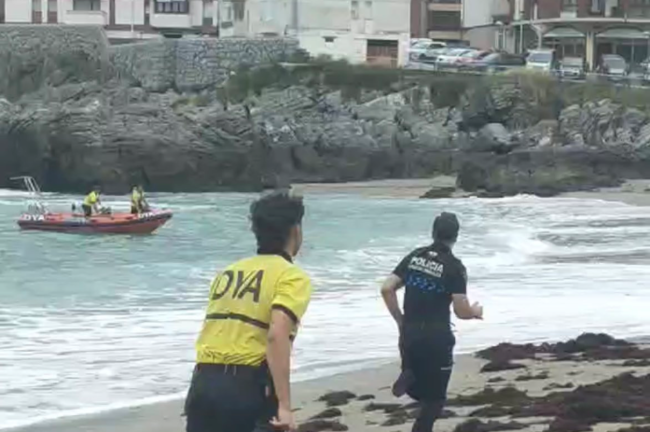 Un policía local de Castro tratando de atrapar al hombre que se adentró al mar.