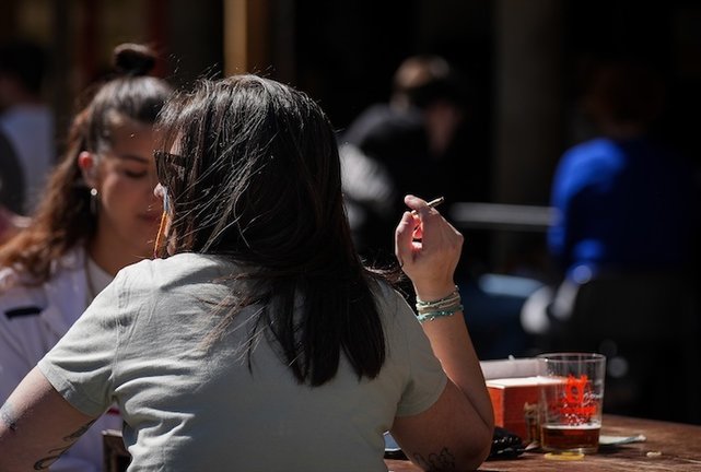 Una persona fumando en una terraza. EP