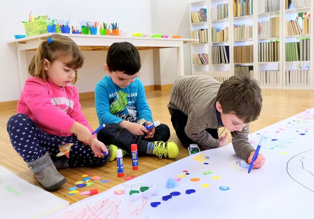 Tres niños pintando en una guardería. / Alerta